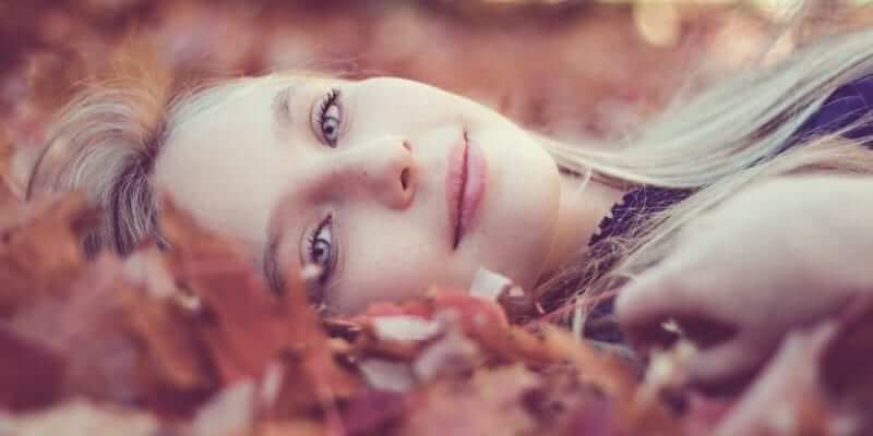 Woman Lying Down On Autumn Leaves - What is Self-Acceptance? 